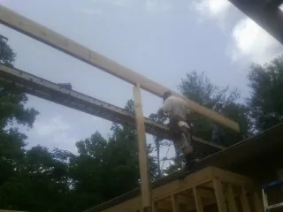 Carpenter setting a ridge beam over a new addition frame — Ice Dam Removal by Roofing Brothers in Elk Creek